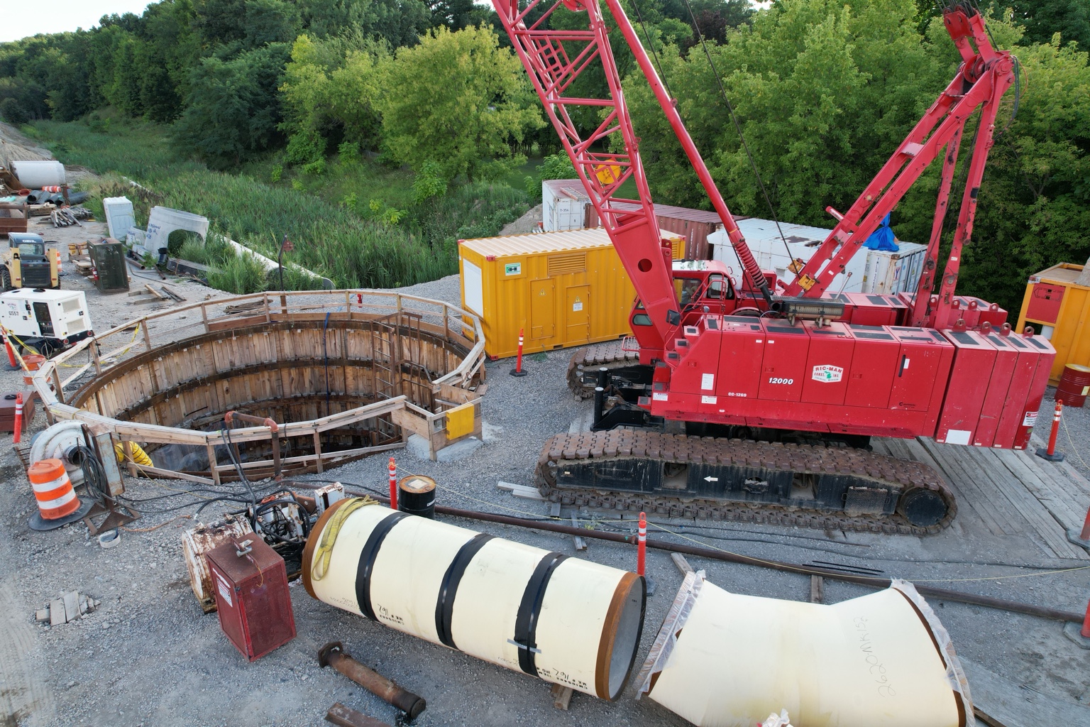 PCM drone photograph of a red crane beside a circular construction shaft